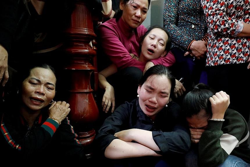 Relatives and friends surrounding the ambulances carrying the bodies of Vietnamese Hoang Van Tiep and Nguyen Van Hung, among the 39 victims found dead in the back of a truck in Britain last month. The bodies of 16 victims arrived in Vietnam in the ea