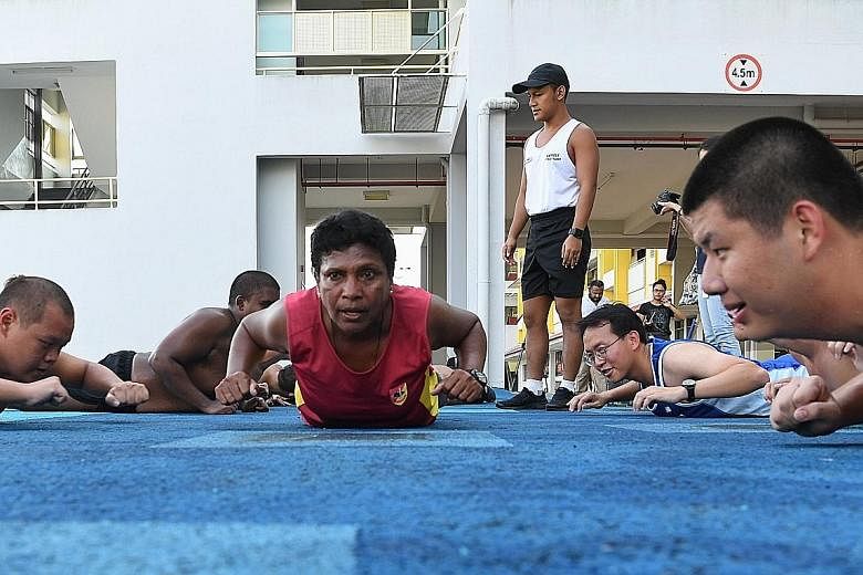 First Warrant Officer Margaret Leon participating in the prone row exercise together with recruits from the Basic Military Training Centre's Cougar Company on Pulau Tekong yesterday. The oldest woman commander in the army, 1WO Leon believes that to m