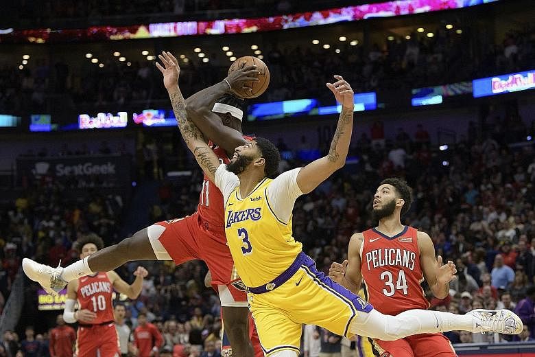 LA Lakers forward Anthony Davis battling for the ball with New Orleans' Jrue Holiday. It was Davis' first game against his old team, the Pelicans, following his summer move.