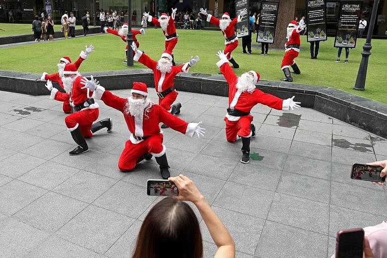 Santas dancing during a flash mob in front of One Raffles Place around 1pm yesterday. There were 10 people in total who were decked from head to toe in Santa Claus outfits to publicise Christmas Wonderland 2019. After the dance, they posed for photos