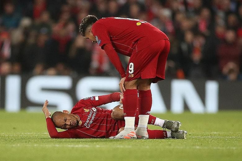 Liverpool's Roberto Firmino checking on teammate and fellow Brazilian Fabinho, who grimaces in pain after getting a knock to his ankle during their 1-1 Champions League Group E draw with Napoli at Anfield on Wednesday.