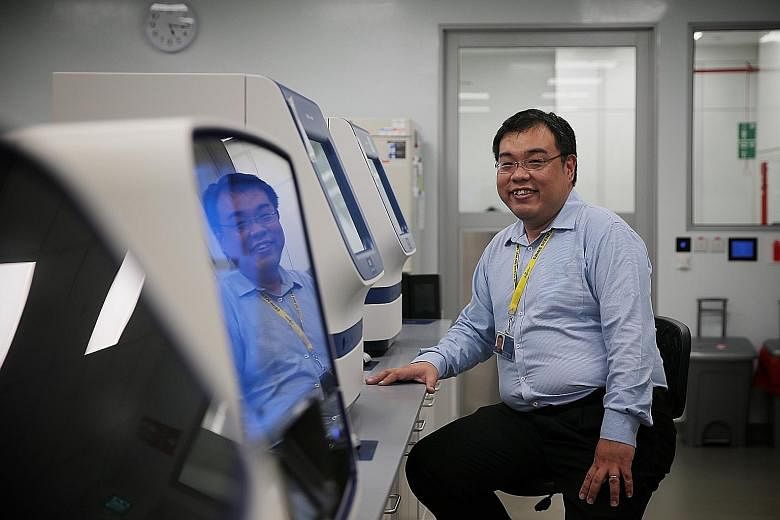 Senior forensic scientist Simon Lim from HTX with genetic analysers that he and his team use to sequence DNA from samples handed over by the police or other Home Team officers. ST PHOTO: JASON QUAH