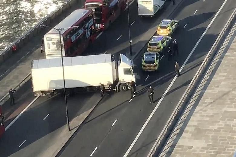 Police surrounding a white truck that stopped diagonally across lanes on London Bridge in the British capital yesterday. Officers described the incident as terror-related, although the circumstances were still unclear.