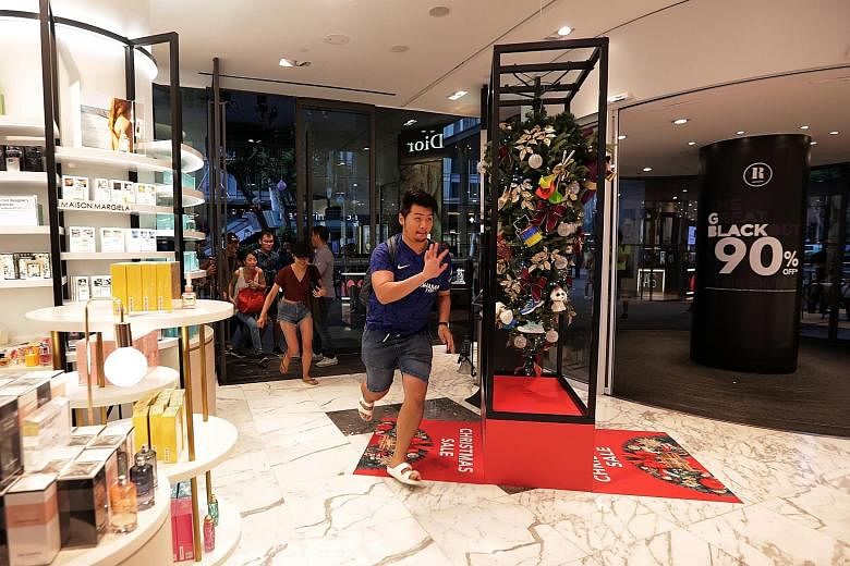 Left: Brisk sales in Metro's outlet at Paragon, which dangled discounts of up to 90 per cent yesterday. Right: Shoppers looking for bargains at the Courts store in Funan. ST PHOTOS: GIN TAY, GAVIN FOO Mr Jonathan Tan, 29, dashing into Robinsons The H