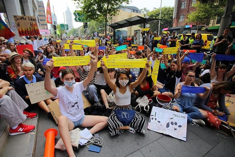 Student activists from the School Strike for Climate Australia holding a "solidarity sit-down" outside the ruling Liberal Party's office in Sydney, Australia, yesterday. PHOTO: EPA-EFE