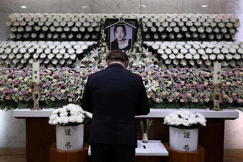 A man paying his respects at a memorial altar for another K-pop star, Goo Hara. The 28-year-old committed suicide six weeks after Sulli's death.