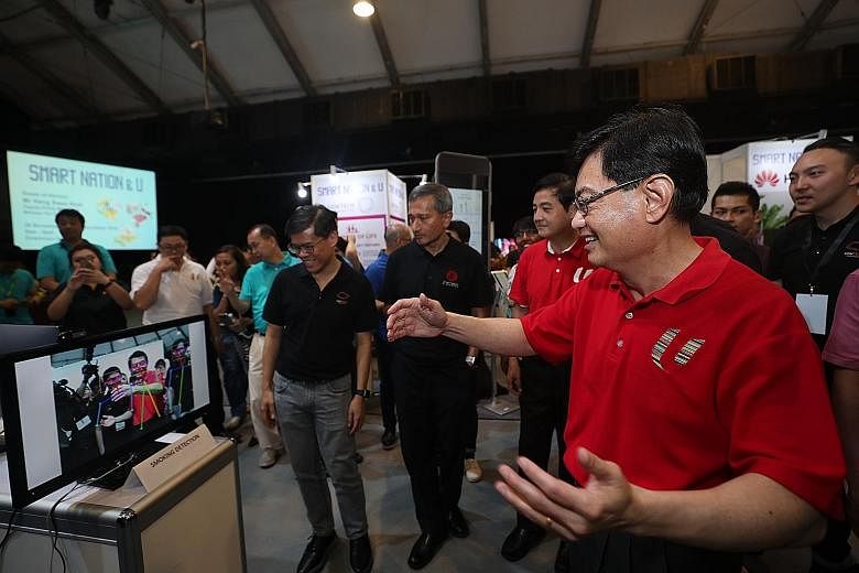 Deputy Prime Minister Heng Swee Keat visiting a booth at the Smart Nation & U event yesterday, where he urged Singaporeans to progress together technologically. The event had activities such as a digital clinic where seniors could learn how to make their 
