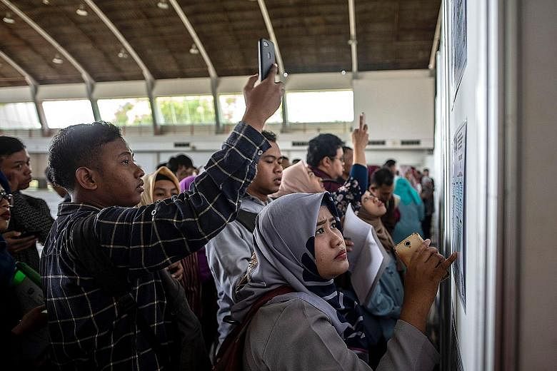 Indonesian job seekers at a job fair in Surabaya in September. Indonesia will coalesce overlapping parts of 74 laws into one "job creation law" that will go before Parliament in January, President Joko Widodo announced on Thursday.