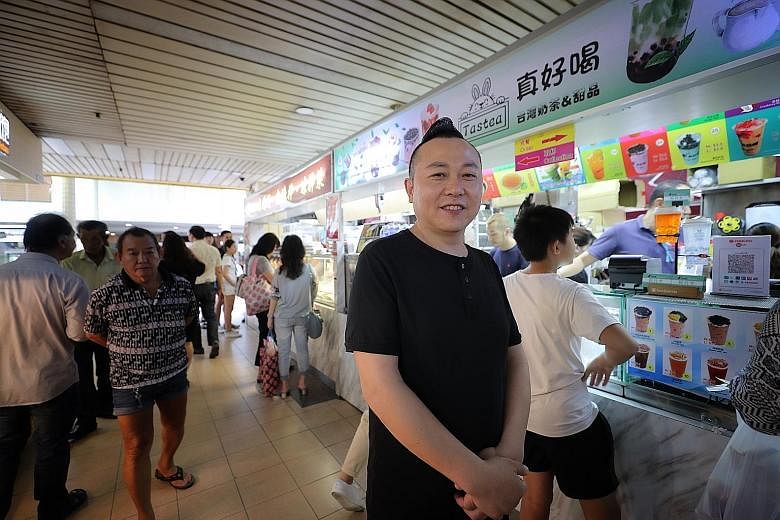 Mr Dai Heng Jiang beside his bubble tea stall and Sichuan cooked food stall (back) outside People's Park Complex in Chinatown. The Sichuan native, who is a permanent resident here, imports ingredients from Sichuan every month and counts as his custom
