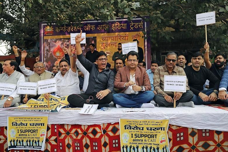 Indian merchants holding placards and shouting slogans during a sit-in protest against Amazon and Walmart last month at Sadar Bazaar, the largest wholesale bazaar in New Delhi. This came even as the government in October announced an investigation in
