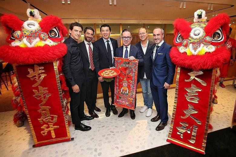 Qantas International chief executive Tino La Spina (second from left), Changi Airport Group chief executive Lee Seow Hiang (third from left) and Qantas chief executive Alan Joyce (with banner) with key designers of Qantas First Lounge at the opening 