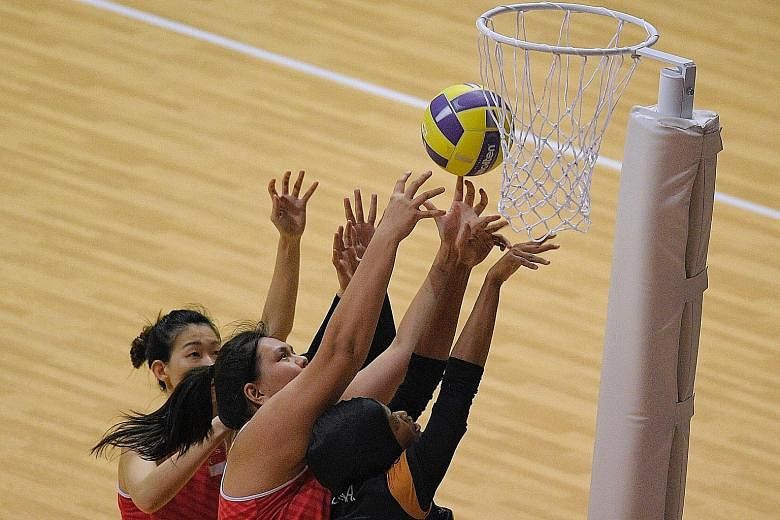 Above: Captain and goal attack Charmaine Soh, goal shooter Lee Pei Shan, wing attack Carmen Goh and the other Singapore netballers are crestfallen after losing 48-42 to Malaysia in the final. Below: Soh and Lee tussling for the ball with Malaysia's N