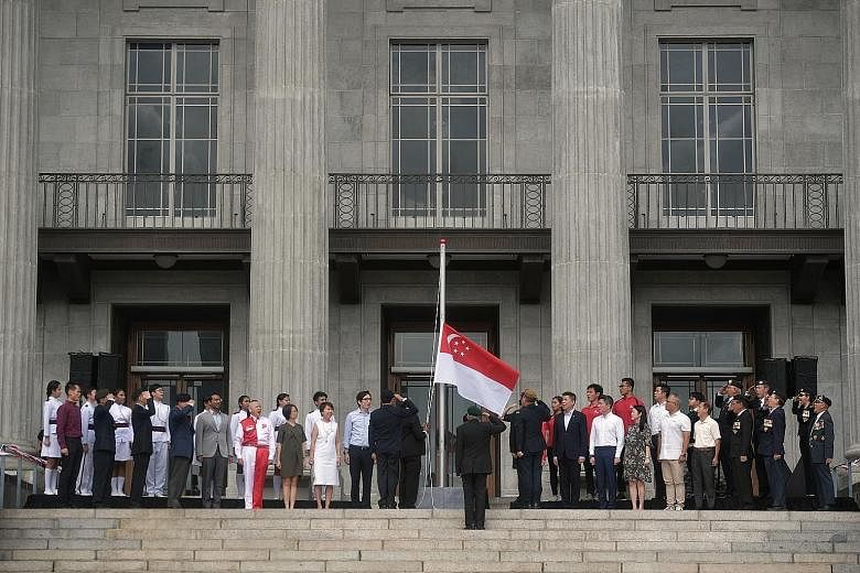 Members of the Singapore Armed Forces Veterans' League saluting during the flag-raising ceremony and singing of the National Anthem at the 60th anniversary commemoration of the national symbols yesterday at the National Gallery Singapore.