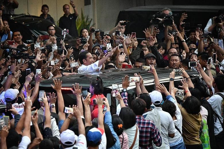 A crowd of supporters cheering Mr Joko Widodo in Jakarta after the presidential election in April. He defeated retired army general Prabowo Subianto to retain power for a second and final term in office in the world's largest Muslim-majority country 