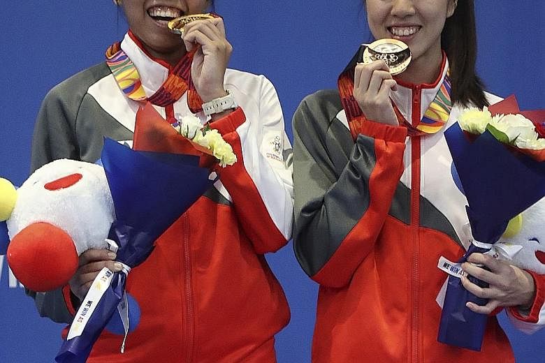 Women's epee champion Kiria Tikanah Abdul Rahman (far left) with bronze medallist Cheryl Lim, whom she beat 15-10 in the semi-finals. Joshua Lim also won a bronze, in the men's foil.
