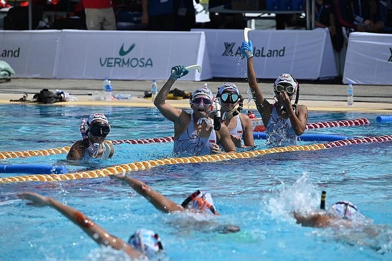 The Singapore women's team raising their sticks in celebration during the 4x4 underwater hockey final against the Philippines, which they won 4-2. PHOTO: LIANHE ZAOBAO