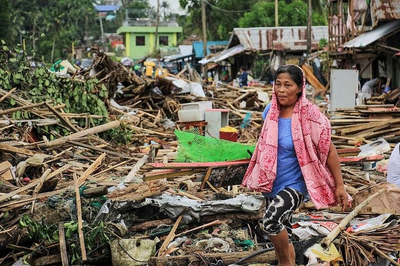A resident surrounded by debris in the wake of Typhoon Kammuri in the city of Sorsogon, south of Manila, on Tuesday. Typhoon Kammuri made landfall on Monday night, prompting the forced evacuation of thousands of residents and the cancellation of hund