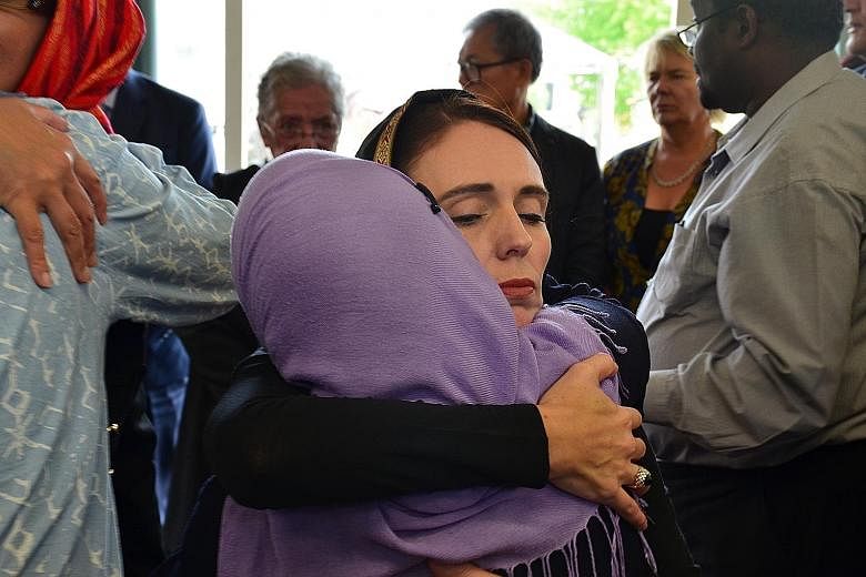 New Zealand PM Jacinda Ardern with members of the Muslim community in the wake of the mass shooting that killed 51 worshippers at two Christchurch mosques on March 16. PHOTO: EPA-EFE