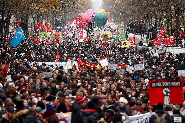 Protesters gathering for a demonstration in Paris yesterday against the French government's pension reform plan. The Eiffel Tower was forced to shut down, while France's vaunted high-speed trains stood still and metro stations across Paris shut their