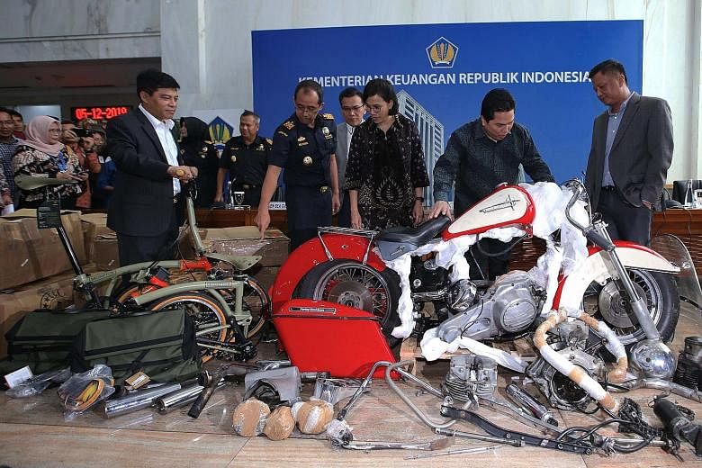 Indonesia's Finance Minister Sri Mulyani and State-owned Enterprises Minister Erick Thohir (second from right) checking the smuggled Harley-Davidson, which had been dismantled and packed into 15 boxes. PHOTO: AGENCE FRANCE-PRESSE Garuda chief executi