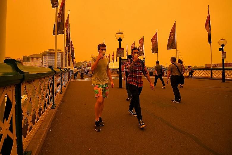 Pedestrians wearing masks as they walked towards the Central Business District as a smokey haze blanketed Sydney yesterday.
