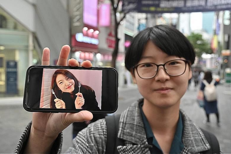 Ms Yoon Ji-hye showing an old photo of herself. More and more South Korean women like her are banding together to reject patriarchal norms, vowing never to wed, have children or even date and have sex.