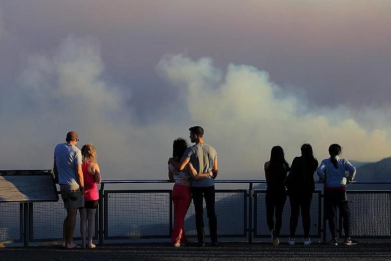 Smoke-filled skies at a lookout point in Katoomba, New South Wales, on Friday. The authorities said yesterday that the worst may be yet to come as no serious rainfall is expected until late next month or later.