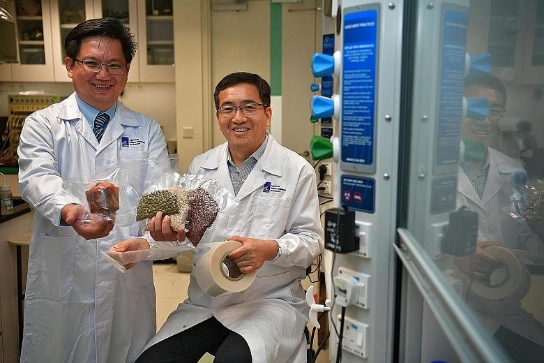 A 2017 photo showing Dou Yee Enterprises vice-president Alex Tan (left) and A*Star scientist Li Xu with examples of food stored in smart packaging, which was developed with A*Star scientists. The firm has gained from FTAs like those covering US-Singa