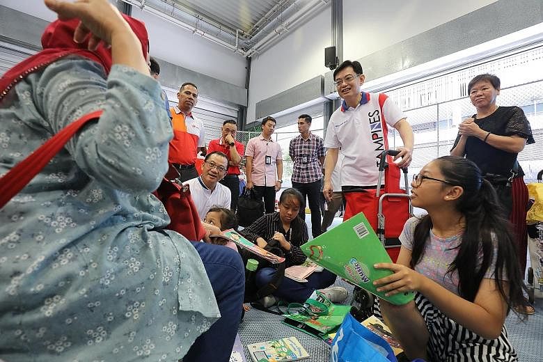 Deputy Prime Minister Heng Swee Keat (third from right) and FairPrice chief executive Seah Kian Peng (left, in white) at the FairPrice Share-A-Textbook and NTUC Back to School events at Our Tampines Hub. The events will be open to the public today.