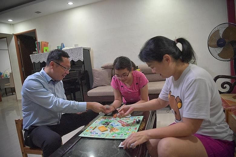 Mr Teo Cher Hwa and his wife, Ms Chew Chiou Pyng, playing Monopoly with their daughter Poh Huan at home. Mr Teo says playing a traditional board game like Monopoly is an excellent way to introduce their two children to the property market and how to 
