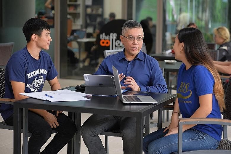 National University of Singapore's Faculty of Arts and Social Sciences dean, Professor Robbie Goh, chatting with two first-year students from his faculty, Mr Ashruff Muhammed Ibrahim, 22, who is keen on pursuing economics, and Ms Nelle Ng, 19, a poli