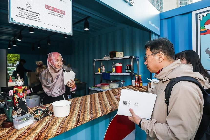 Customers visiting one of the Asean-Korea Food Street stalls selling Indonesian dishes such as mee goreng and nasi goreng. Food at some of the stalls was sold out just half an hour after opening.