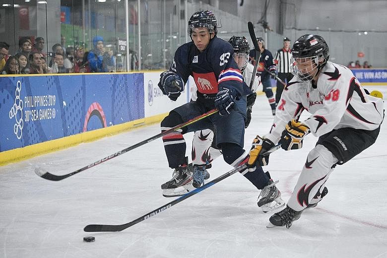 Singapore's Ryan Tan and Thailand's Masato Kitayama tussling for the puck in the SEA Games ice hockey final. Thailand had 55 shots on goal in the 8-0 win. 