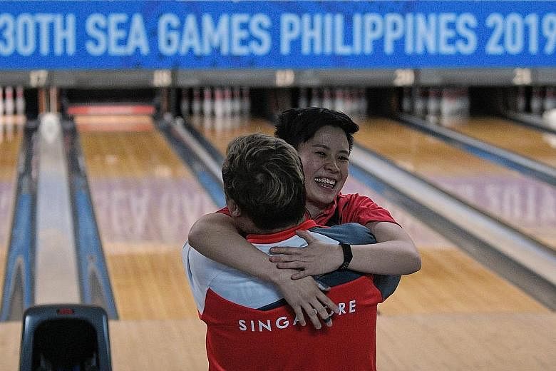 New Hui Fen hugging coach Helmi Chew after defeating Malaysian Siti Safiyah Amirah for the SEA Games women's Masters title in Manila yesterday. 