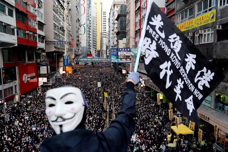 People marching in Hong Kong yesterday. The rally, which began around 3pm, went smoothly but tensions notched up at night when hundreds of protesters in face masks and helmets started building barricades in areas such as Central and Causeway Bay to s