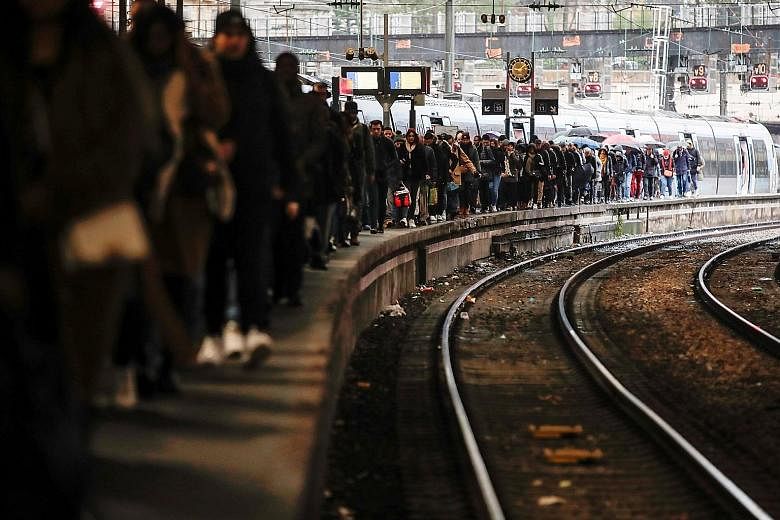 Commuters walking on a platform at Gare Saint-Lazare train station yesterday as a strike continues against the French government's pension reform plans in Paris. Citing safety risks, the SNCF national rail network warned travellers to stay home. PHOT