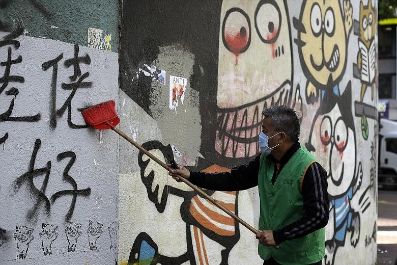 A worker cleaning a wall vandalised in the rally held on Sunday. PHOTO: ASSOCIATED PRESS