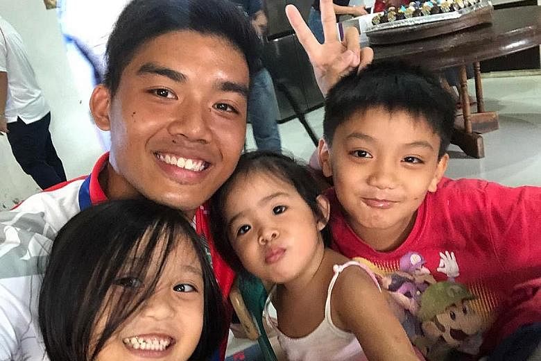 Singapore's gold-medal winning softballer Ziglar Oh with children from Duyan Ni Maria, a children's home in Clark yesterday. He was among 16 Singapore softball and wakeboard athletes who spent time interacting and chatting with the children, and brou