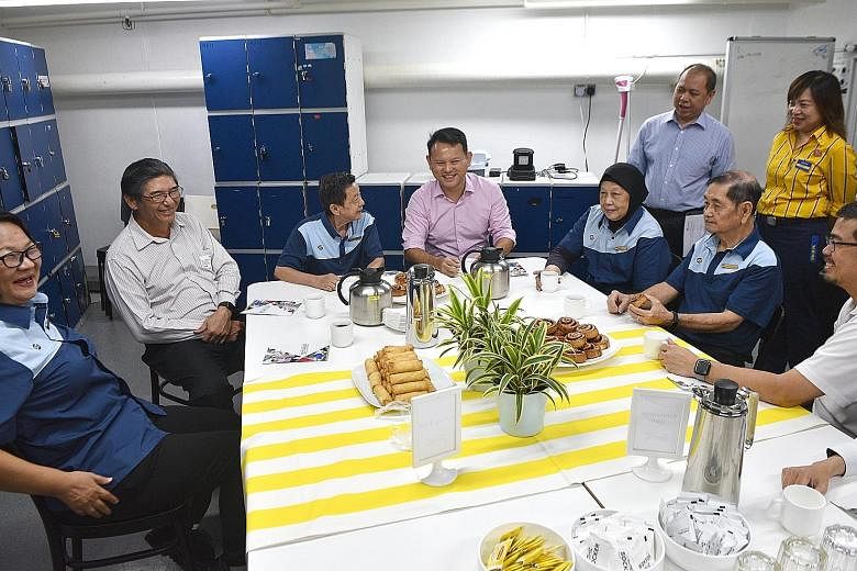 Minister of State for Manpower Zaqy Mohamad (centre), Singapore National Employers Federation member Jeffrey Chua (second from left) and National Trades Union Congress assistant secretary-general Zainal Sapari (right) with cleaners (from left) Lew Ch