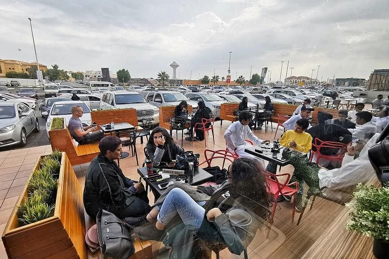 Men and women at a cafe in Khobar, Saudi Arabia, yesterday. Many restaurants and cafes in the country have separate entrances for women and partitions or rooms for families where women are not visible to single men.