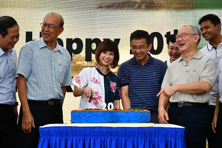 Senior Minister of State for the Environment and Water Resources Amy Khor cutting a cake during a ceremony at Semakau Landfill to mark its 20th anniversary yesterday. She is joined by (from far left) Mr Khoo Seow Poh, deputy chief executive (planning, cor