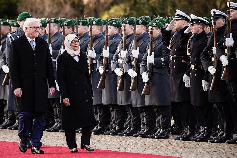 Left: President Halimah inspecting a military guard of honour contingent with German President Frank-Walter Steinmeier during a ceremonial welcome at the Schloss Bellevue in the German capital yesterday.