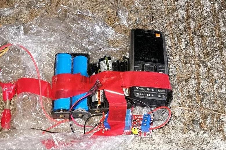 Above: Police officers with evidence of the two homemade bombs in Hong Kong. Left: The bombs were found at Wah Yan College in Wan Chai. They were complete, fully functional and ready to be activated by mobile phone, said a bomb disposal officer. PHOT