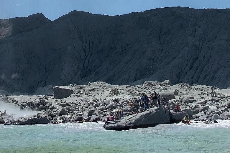 Tourists waiting to leave White Island in New Zealand on Monday, following the eruption of the volcano. Three weeks before it erupted, the volcano showed signs of "moderate and heightened volcanic unrest". PHOTO: ASSOCIATED PRESS