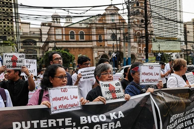 Filipino activists in Manila urging an end to martial law in Mindanao during a rally yesterday to observe Human Rights Day. PHOTO: REUTERS