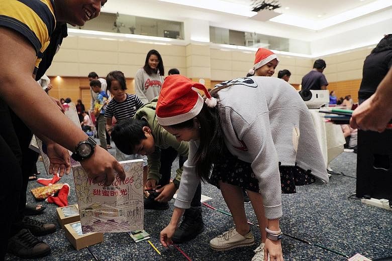 Children trying to form the longest line they could with items they had at the Share-a-Gift party at Singapore Press Holdings (SPH) News Centre auditorium in Toa Payoh yesterday. They were among 140 people - beneficiaries and caregivers - at the even
