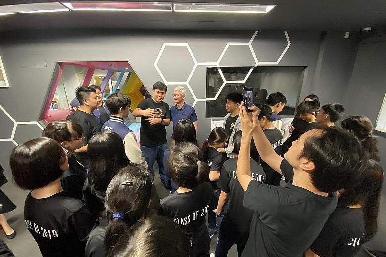 Apple chief executive Tim Cook meeting students at the School of Science and Technology, Singapore yesterday. It is the only school in Singapore to run a compulsory coding programme for all Grade 9 students using Swift, Apple's programming language.