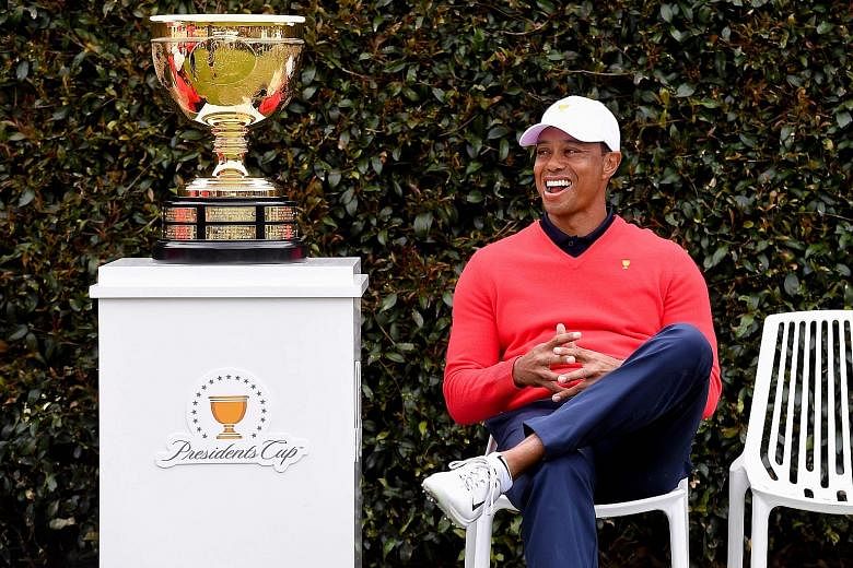 Tiger Woods, the United States' playing captain, is in good spirits while waiting for teammates during a photo session at the Presidents Cup at Royal Melbourne in Australia. The Americans are defending their title in the biennial matchplay event agai