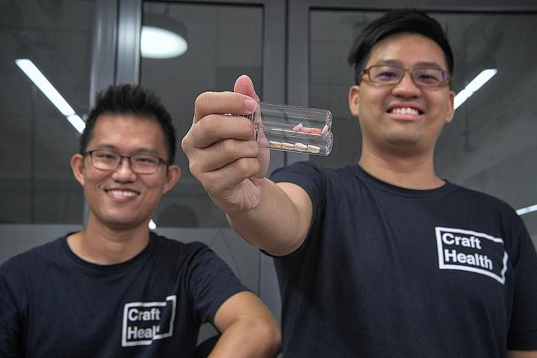 Dr Lim Seng Han (far left) and Dr Goh Wei Jiang of Craft Health with pills made using technology they discovered, which can 3D-print tablets that combine multiple active ingredients in one pill, with different dosages and release times.