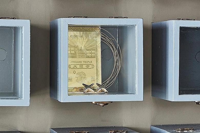Made up of 118 square boxes, the display holds items such as a gold plate and gold cufflinks.